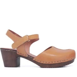 Zapatos tacón Redlove marrones Elena cogidos por el tobillo y piso madera